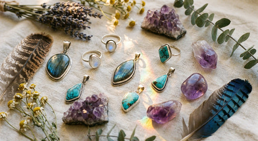 A golden-lit flat lay of handcrafted moonstone, labradorite, turquoise, and amethyst jewelry arranged on linen with dried wildflowers and eucalyptus, evoking a bohemian bridal aesthetic.