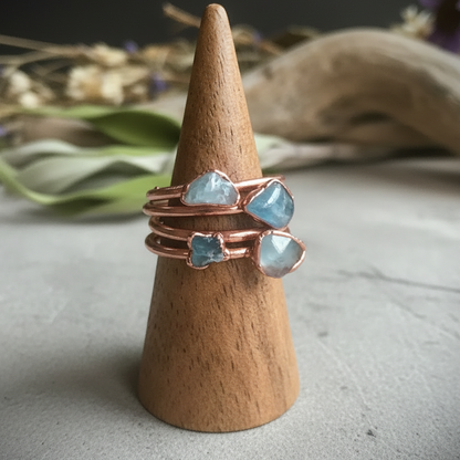 Dainty aquamarine rings cone display on light grey slate