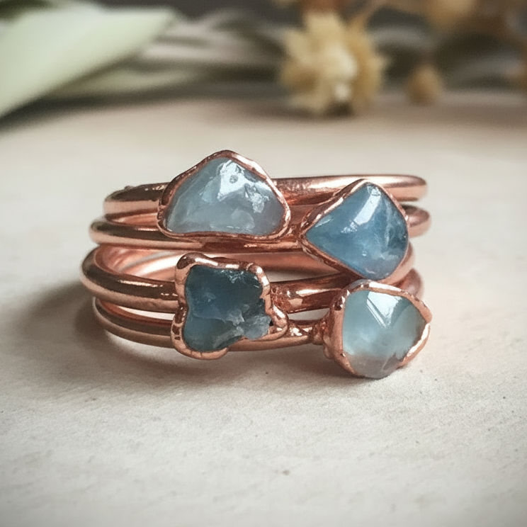 Dainty aquamarine rings stacked group on light grey slate