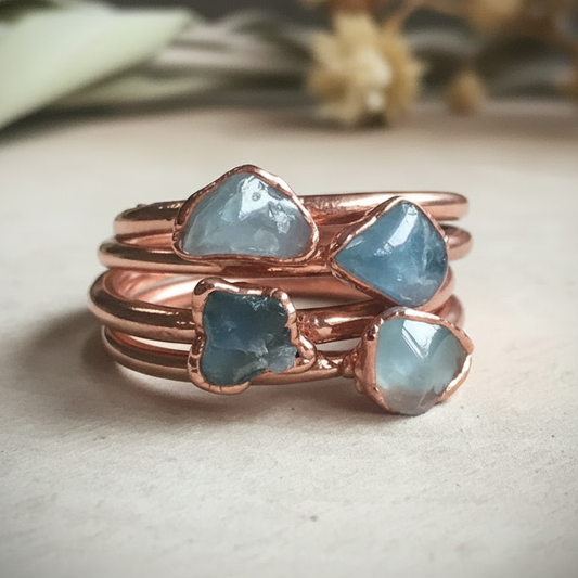 Dainty aquamarine rings stacked group on light grey slate