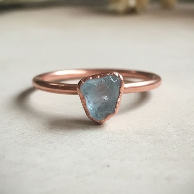 Dainty aquamarine single ring hero on light grey slate