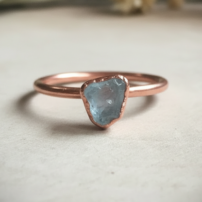 Dainty aquamarine single ring hero on light grey slate