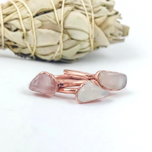 Three dainty rose quartz electroformed copper rings on white background, bright copper finish