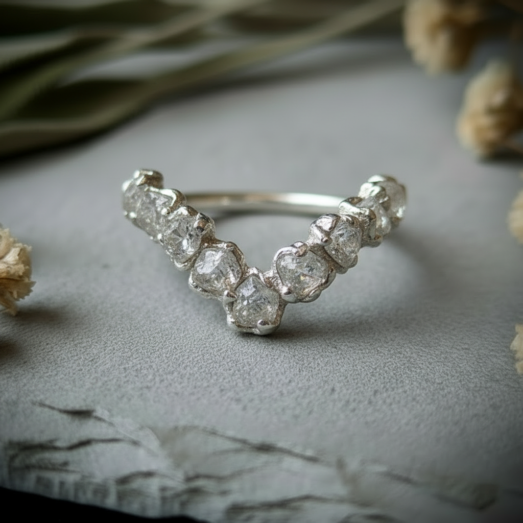 Raw clear quartz silver-plated chevron ring side angle on light grey slate