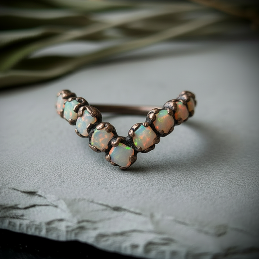 Raw Ethiopian opal chevron ring in antique copper electroformed finish on light grey slate