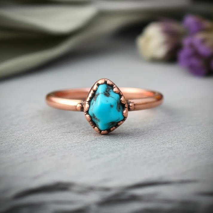 Raw Sonoran turquoise single stone electroformed copper ring, bright copper finish, on light grey slate