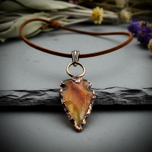 Carnelian arrowhead pendant necklace on light grey slate