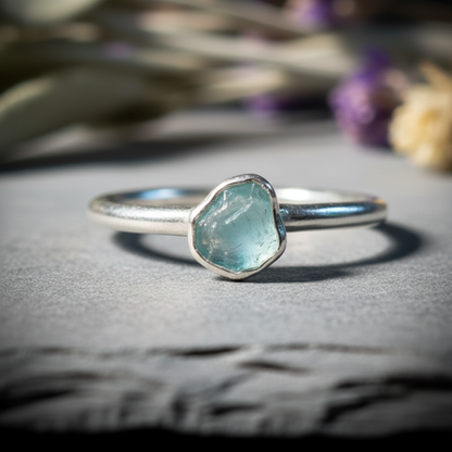 Dainty raw aquamarine stacking ring in silver plated electroformed copper, hero upright on light grey slate