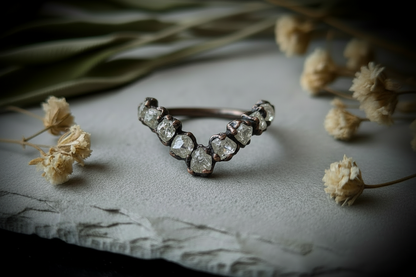 Raw clear quartz chevron ring wide hero flat-lay with dried botanicals surrounding the ring