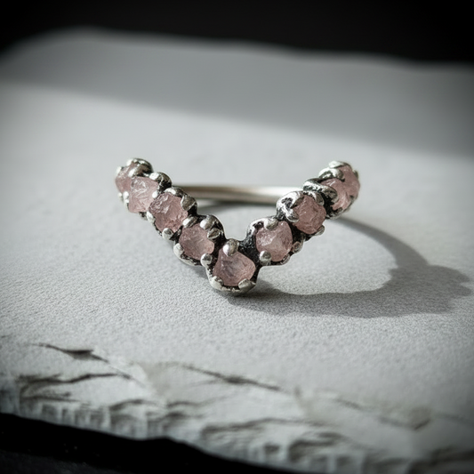 Raw rose quartz chevron ring in silver-plated copper on light grey slate, hero close-up