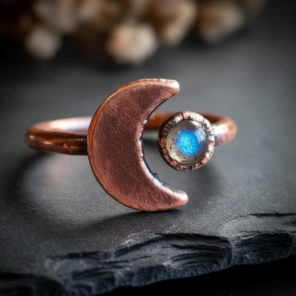 Labradorite crescent moon ring hero on dark charcoal slate