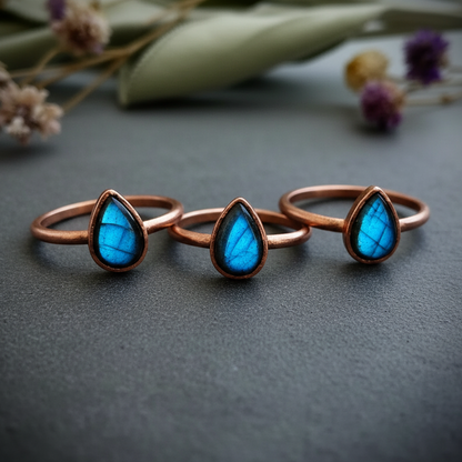 Labradorite trio cluster brand background with blue flash on dark charcoal slate