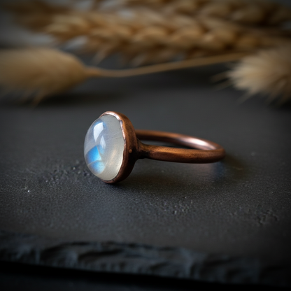 Oval moonstone low angle side profile on dark charcoal slate