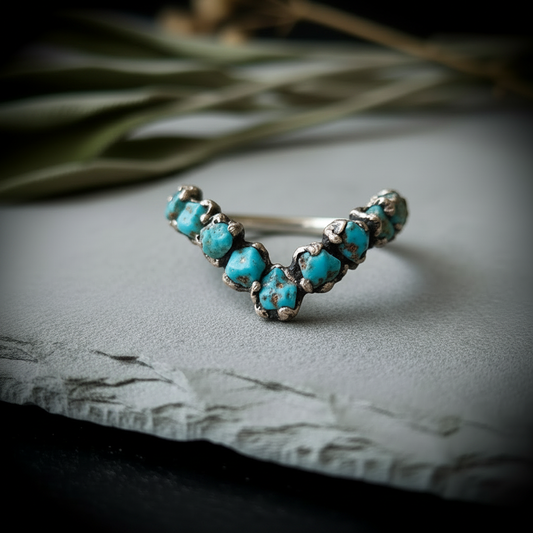 Raw turquoise silver-plated chevron ring on light grey slate with dried botanicals