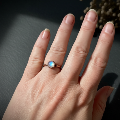 Round moonstone hand shot on dark charcoal slate