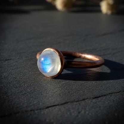 Round moonstone low angle side profile on dark charcoal slate